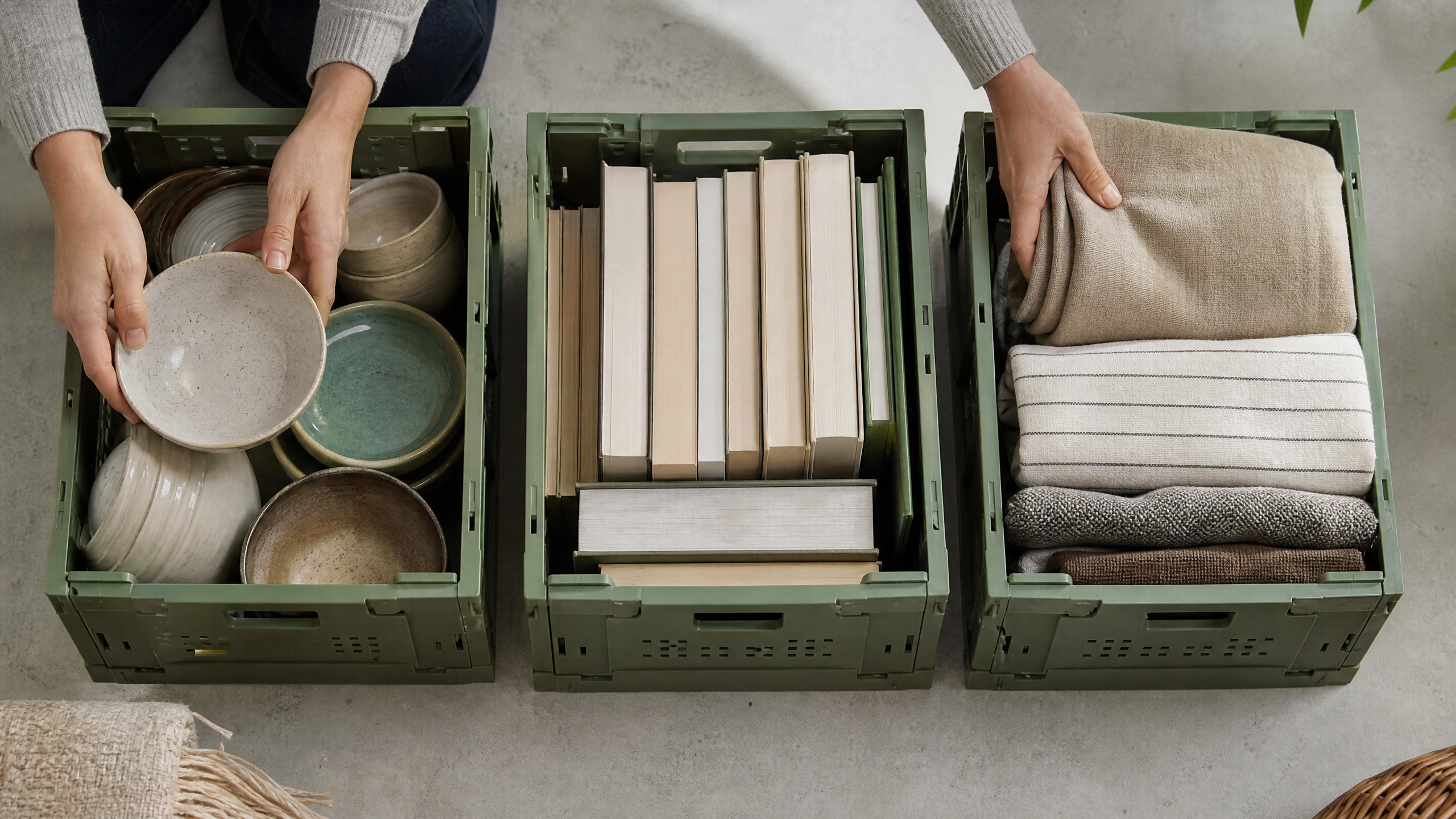 Hände sortieren saubere Haushaltsgegenstände in neutrale Kisten für Wiederverwendung und Recycling.